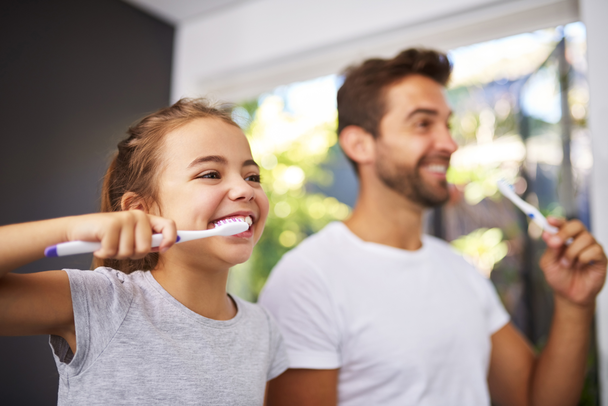 Dad brushing teeth with daughter