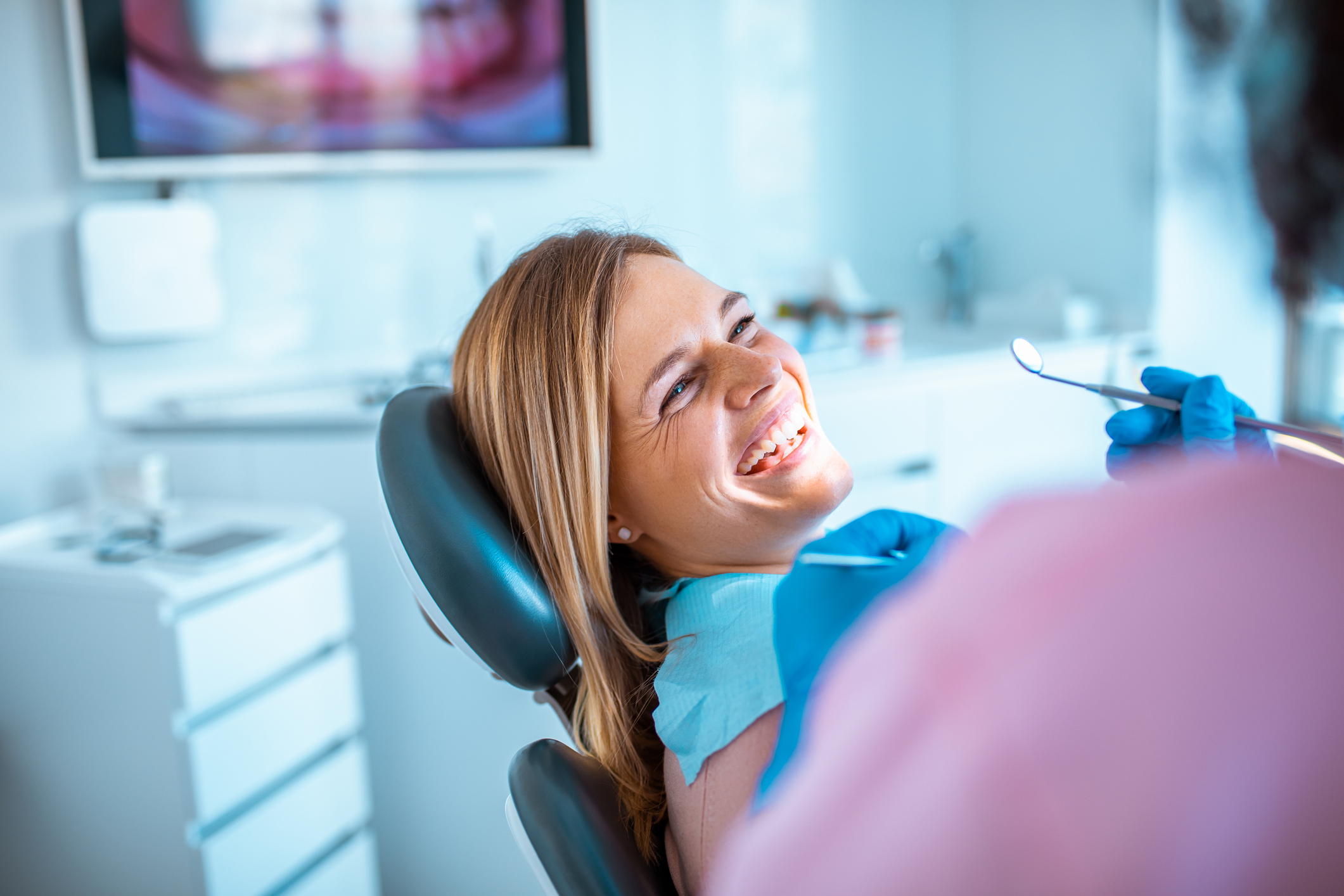 Woman at dentist, smiling while getting a check up