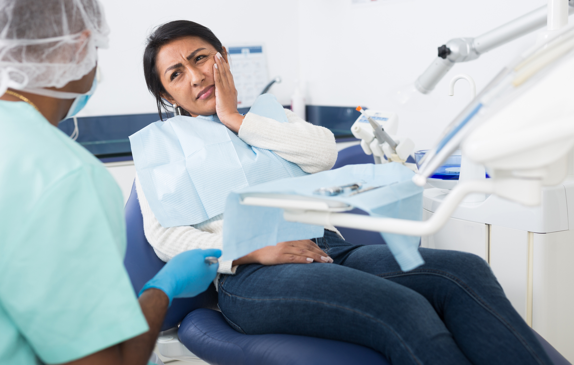 Woman patient talking to dentist and complaining of toothache